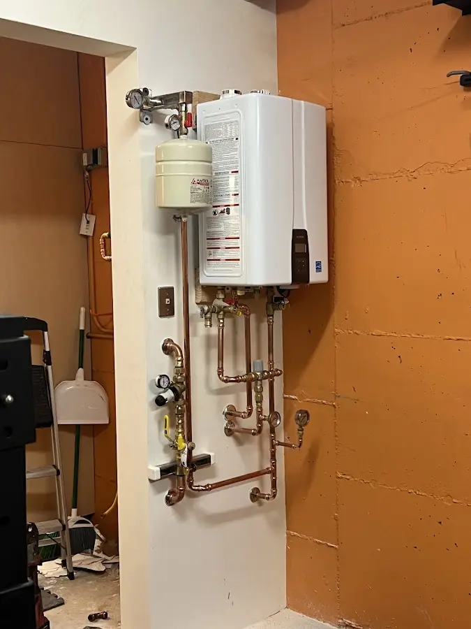 Plumbing technician inspecting water heater connections in Goldsboro